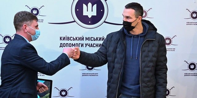 Former Ukrainian boxer Wladimir Klitschko (right) greets a staff member after he registered as a volunteer during a visit to a recruitment center in Kyiv Feb. 2, 2022.