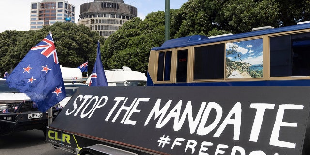 Protesters wave flags from vehicles parked in the streets outside the parliament building (behind) in Wellington on February 8, 2022, during a protest against Covid restrictions, modeled after a similar protest in Canada. (Photo by Marty MELVILLE/AFP) (Photo by MARTY MELVILLE/AFP via Getty Images)