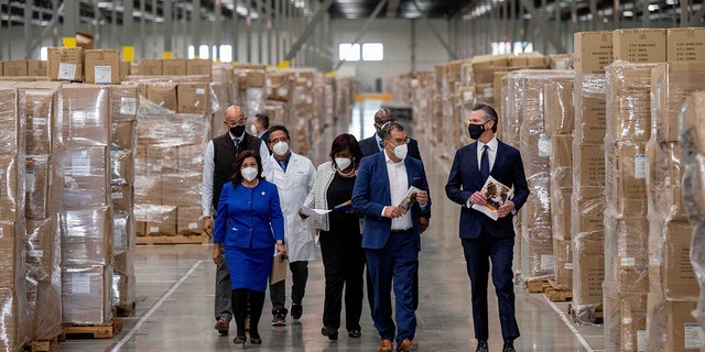 Gov. Gavin Newsom, right, walks through rows of boxed PPE with dignitaries and elected officials, as he prepares to announce the next phase of Californias COVID-19 response called SMARTER, during a press conference at the UPS Healthcare warehouse in Fontana on Thursday, Feb. 17, 2022.  (Photo by Watchara Phomicinda/MediaNews Group/The Press-Enterprise via Getty Images)