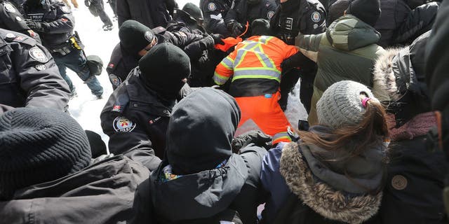 Ottawa Police move a line of protesters from the intersection at Sussex and Rideau Streets in Ottawa on Feb. 18, 2022.