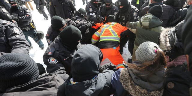 Ottawa Police move a line of protesters from the intersection at Sussex and Rideau Streets in Ottawa on Feb. 18, 2022.