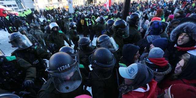 Police clash with convoy protesters in Ottawa, Ontario, on Feb. 18, 2022.