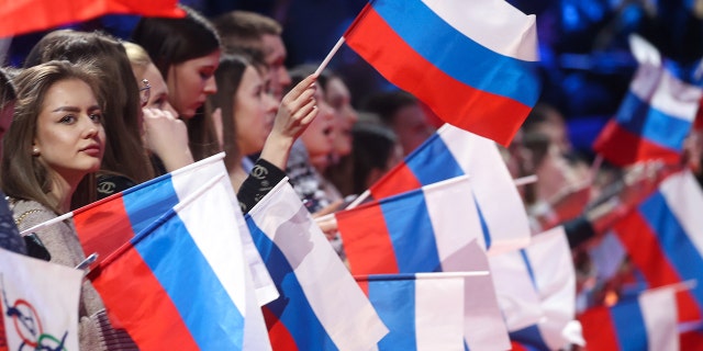 Fans wave Russian flags to honor Russian athletes who competed at the Beijing 2022 Olympics.