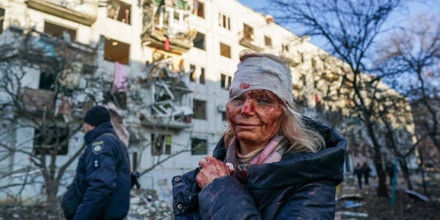 A wounded woman is seen after an airstrike damaged an apartment complex in city of Chuhuiv, Kharkiv Oblast, Ukraine on February 24, 2022.