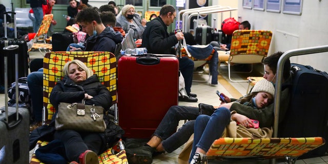 Passengers rest on camp beds in a temporary shelter inside a building of the railway station after arriving on a train from Kiev in Ukraine to Przemysl, Poland on February 25, 2022. Russian invasion on Ukraine can cause a mass exodus of refugees to Poland. (Photo by Beata Zawrzel/NurPhoto via Getty Images)