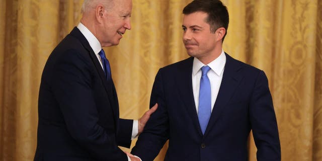 President Biden shakes hands with Transportation Secretary Pete Buttigieg 