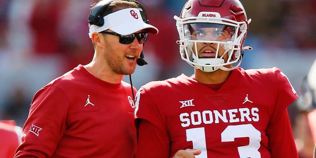 Head coach Lincoln Riley smiles with quarterback Caleb Williams #13 of the Oklahoma Sooners after his 74-yard touchdown run against the Iowa State Cyclones in the first quarter at Gaylord Family Oklahoma Memorial Stadium on November 20, 2021 in Norman, Oklahoma.  The Sooners won 28-21.  