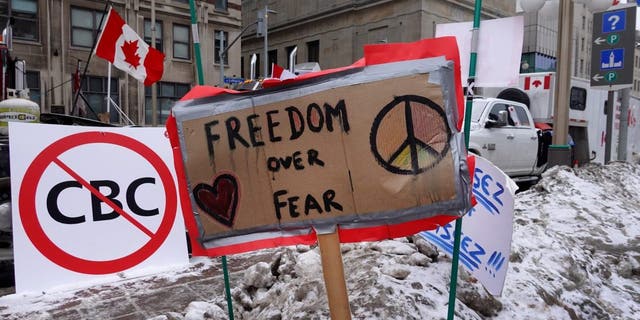 Signs of support are planted in a snow bank near the parliament building where trucks have formed a blockade of streets as a demonstration led by truck drivers protesting vaccine mandates continues on February 16, 2022 in Ottawa, Ontario, Canada Prime Minister Justin Trudeau has invoked the Emergencies Act for the first time in Canada's history to try to put an end to the blockade which is now in it's third week.