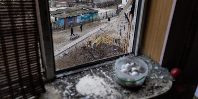 People take photos of the exterior of a residential block hit by an early morning missile strike on Feb. 25, 2022, in Kyiv, Ukraine.