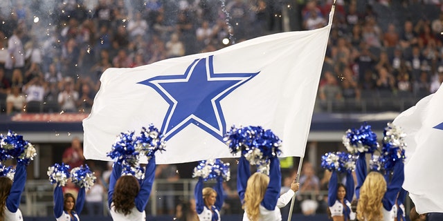 Dallas Cowboys cheerleaders on the field during a preseason game at AT and T Stadium.