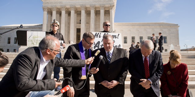 Religious activists pray outside the Supreme Court in Washington, DC, on November 6, 2013.