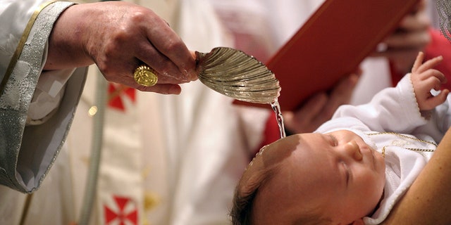 Pope Benedict XVI baptizes a newborn baby in Michelangelo's Sistine Chapel on Jan. 10, 2010, in Vatican City, Vatican. 