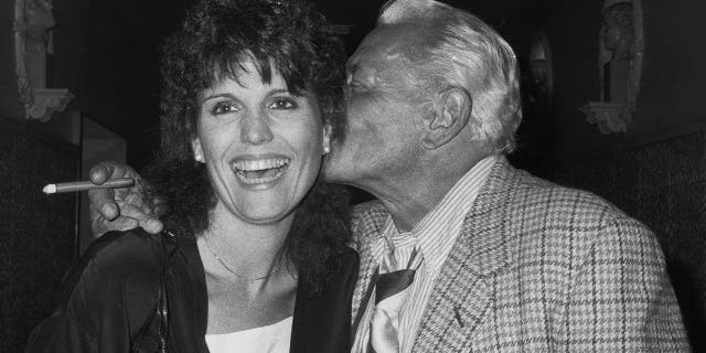 Desi Arnaz (1917-1986) kissing his daughter, American actress and singer Lucie Arnaz, on the cheek, circa 1985.