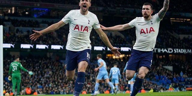 Tottenham's Harry Kane, left, celebrates with Tottenham's Pierre-Emile Hojbjerg after scoring his side's second goal during the English Premier League soccer match between Manchester City and Tottenham Hotspur, at the Etihad stadium in Manchester, England, Saturday, Feb. 19, 2022.