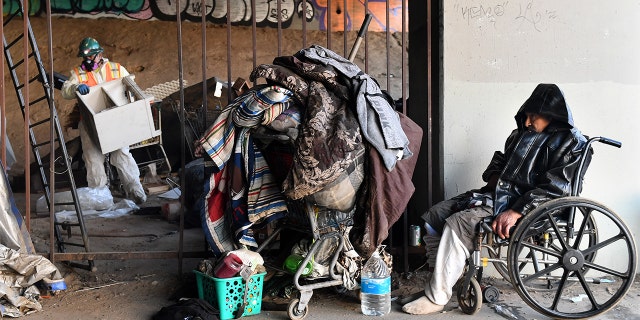 FILE – A homeless person who goes by the name "Richard" is kicked out of a homeless encampment under the 405 freeway in Inglewood, Kalifornië, op Januarie 25, 2022, as work crews clean-up personal belongings and trash in preparation for the Super Bowl.