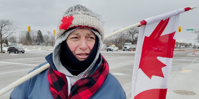 A demonstrator stands near the Ambassador Bridge in Windsor, Canada, on Sunday morning