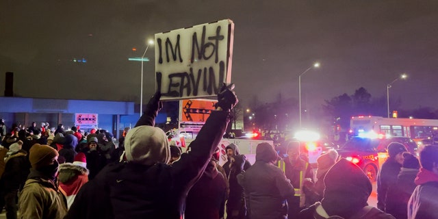 The participant of the action is holding on "I'm not leaving" a sign for the sixth consecutive night of protests against the blocking of the Ambassador Bridge in Windsor, Canada