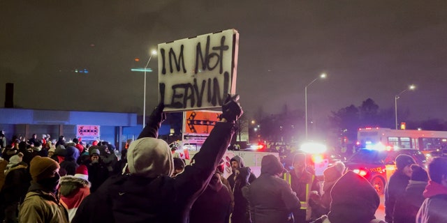 The participant of the action is holding on "I'm not leaving" a sign for the sixth consecutive night of protests against the blocking of the Ambassador Bridge in Windsor, Canada