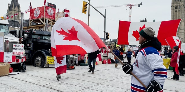 Uomo che sventola la bandiera canadese il 20° giorno del raduno del Giorno dell'Indipendenza a Ottawa.