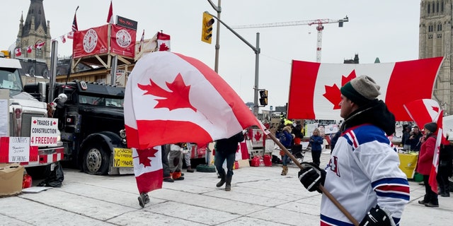 Uomo che sventola la bandiera canadese il 20° giorno del raduno del Giorno dell'Indipendenza a Ottawa.