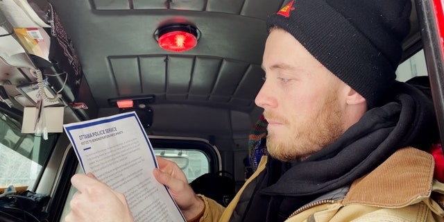 Un camionneur canadien lit l'avertissement de la police qu'il sera arrêté si les manifestants ne partent pas