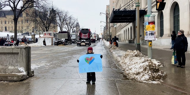 Canadian truckers feel vilified by Trudeau 5 A boy holds a "Thank You Truckers" sign as he walks through the line of trucks in Ottawa