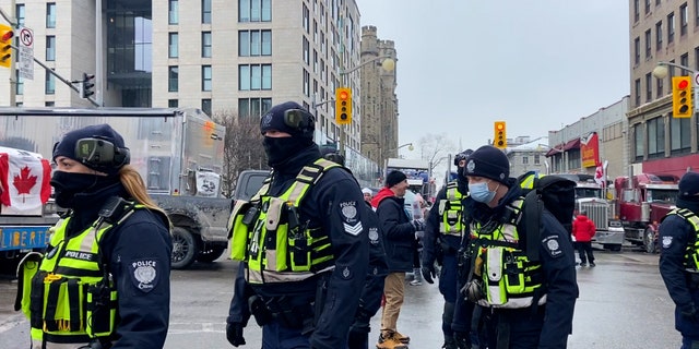 Police in Ottawa, Ontario walk through the crowd at the