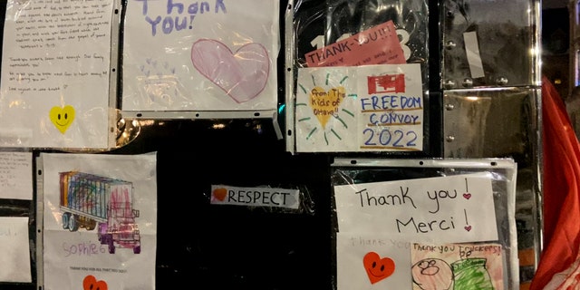 A trucker hangs thank you notes received from supporters of the movement on the side of his truck