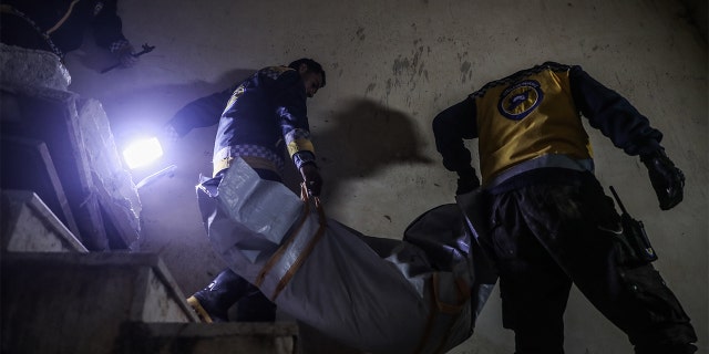 Men carry the body of a child who was killed in a U.S. raid in the town of Atmeh, Syria. ISIS leader Abu Ibrahim al-Hashimi al-Qurayshi died in a suicide explosion that killed members of his family during the raid, the U.S. said.
