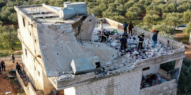 People inspect a destroyed house following an operation by the U.S. military in the Syrian village of Atmeh, in Idlib province, Syria, Thursday, Feb. 3, 2022. ISIS leader Abu Ibrahim al-Hashimi al-Qurayshi died in a suicide explosion during the raid, the U.S. said.