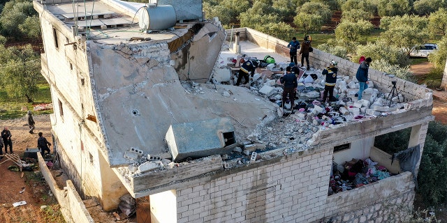 People inspect a destroyed house following an operation by the U.S. military in the Syrian village of Atmeh, in Idlib province, Syria, Thursday, Feb. 3, 2022. ISIS leader Abu Ibrahim al-Hashimi al-Qurayshi died in a suicide explosion during the raid, the U.S. said.