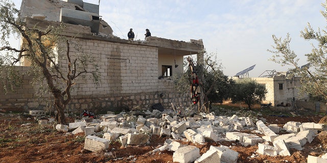People check at a destroyed house after an operation by the U.S. military in the Syrian village of Atmeh. (AP Photo/Ghaith Alsayed)