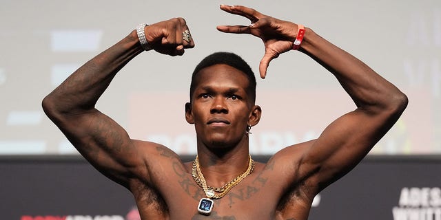 Israel Adesanya of Nigeria poses on the scale during the UFC 271 ceremonial weigh-in at Toyota Center Feb. 11, 2022, in Houston.