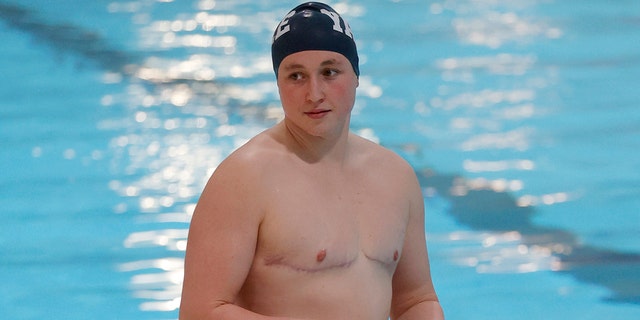 Yale's Iszac Henig stands on the pool deck before warming up for an event at the Ivy League Women's Swimming and Diving Championships at Harvard University, Thursday, Feb. 17, 2022, in Cambridge, Mass. Henig, who is transitioning to male but hasn't begun hormone treatments yet, is swimming for Yale's women's team.