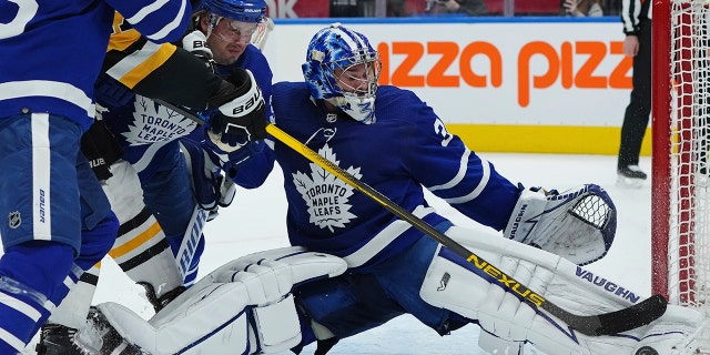 Toronto Maple Leafs goaltender Jack Campbell (36) makes a save on Pittsburgh Penguins forward Bryan Rust (17) as Maple Leafs defenseman Justin Holl (3) defends during the first period of an NHL hockey game Thursday, Feb. 17, 2022, in Toronto.