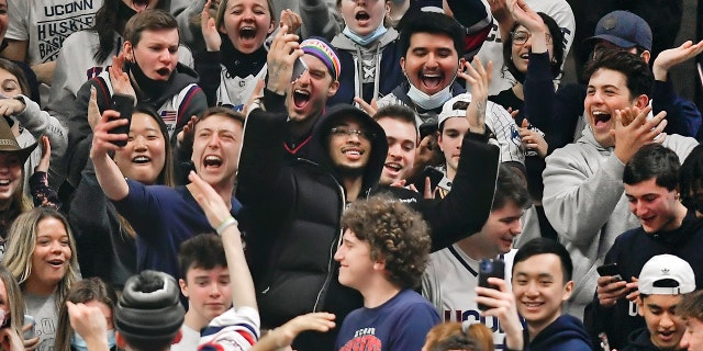 Charlotte Hornets guard James Bouknight, center, gestures from the student section after being ejected from his courtside seats during the Xavier game Saturday, Feb. 19, 2022, in Storrs, Connecticut.