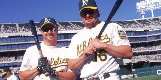 Brothers Jason Giambi (# 16) and Jeremy Giambi of the Oakland A's pose together before a game at Network Associates Coliseum in Oakland, California.