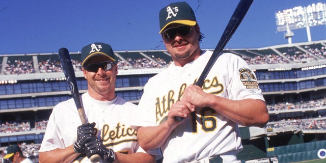 Brothers Jason Giambi (#16) and Jeremy Giambi of the Oakland A's pose together before a game at Network Associates Coliseum in Oakland, California.