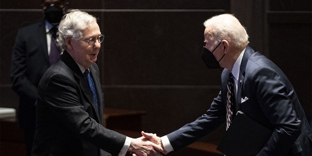 President Biden shakes hands with Senate Minority Leader Mitch McConnell, a Republican from Kentucky, during the National Prayer Breakfast