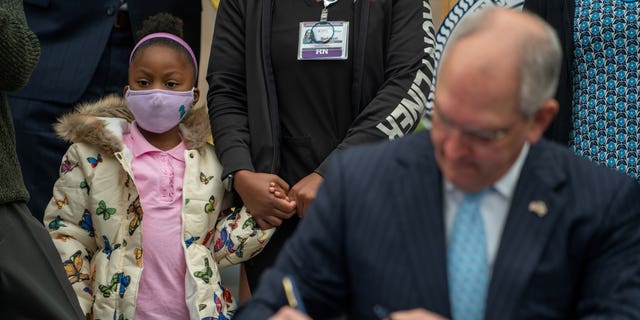 Descendants of Homer Plessy, Caylee Plessy, 4, stands with her mother Rasheedah Plessy, as Louisiana Governor John Bel Edwards signs a pardon for Homer Plessy, the plaintiff in the 1896 U.S. Supreme Court case which upheld the "separate but equal" doctrine that allowed for decades of segregationist laws against Black people, in New Orleans, Louisiana, U.S., January 5, 2022. REUTERS/Kathleen Flynn