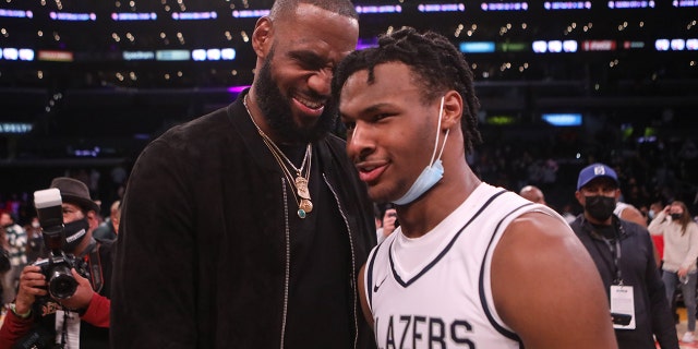 Lebron James entra a la cancha para felicitar a su hijo Bronny James después de la victoria de su equipo en Sierra Canyon sobre St. Vincent-St.  Mary en The Chosen-1 Invitational High School Basketball Showcase en Staples Center en Los Ángeles el 4 de diciembre de 2021.