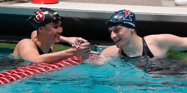 Pennsylvania's Lia Thomas, right, is congratulated by Harvard's Samantha Shelton after Thomas set a meet and pool record in the 200-yard freestyle final at Ivy League women's swimming and diving championships Friday, Feb. 18, 2022, in Cambridge, Mass.