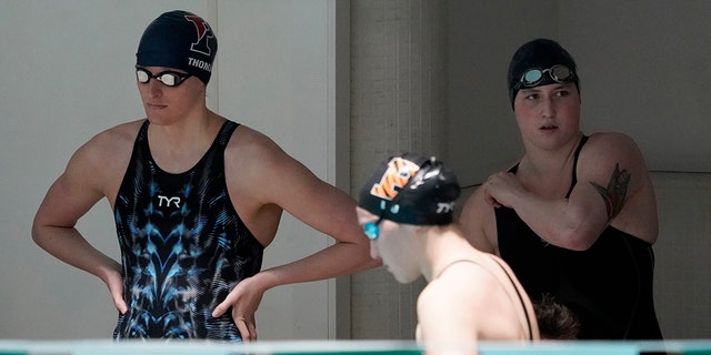Penn's Lia Thomas, 剩下, and Yale's Iszac Henig, 对, prepare to swim in separate qualifying heats of the 100-yard freestyle at the Ivy League Women's Swimming and Diving Championships at Harvard University, 星期六, 二月. 19, 2022, in Cambridge, 弥撒.