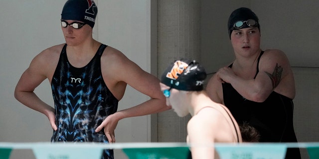 Penn's Lia Thomas, 剩下, and Yale's Iszac Henig, 对, prepare to swim in separate qualifying heats of the 100-yard freestyle at the Ivy League Women's Swimming and Diving Championships at Harvard University, 星期六, 二月. 19, 2022, in Cambridge, 弥撒.