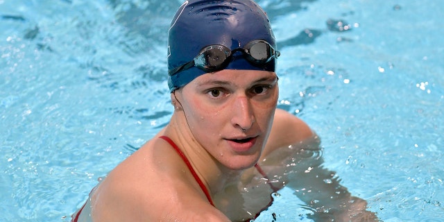 Penn transgender swimmer Lia Thomas speaks to her coach after winning the 500-meter freestyle during an NCAA college swimming meet with Harvard Jan. 22, 2022, at Harvard University in Cambridge, Mass.