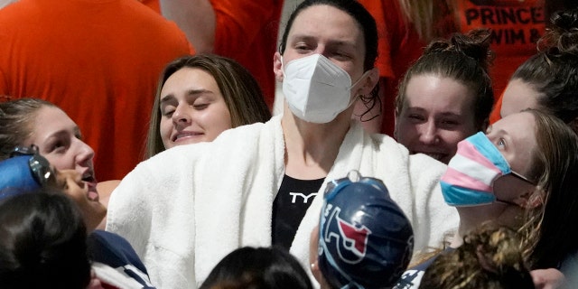 Lia Thomas de Penn lidera al equipo en una ovación antes de los eventos de relevos en los Campeonatos de Natación y Buceo Femenino de la Ivy League en la Universidad de Harvard, el miércoles 16 de febrero de 2022, en Cambridge, Massachusetts.