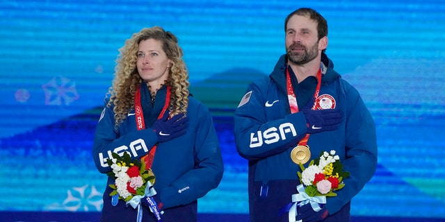 U.S. gold medalists Lindsey Jacobellis and Nick Baumgartner celebrate during a medal ceremony for the mixed team snowboard cross at the 2022 Winter Olympics, Saturday, Feb. 12, 2022, in China.