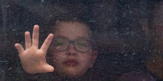 Just after a Ukrainian father said goodbye to his son in Lviv, Ukraine, with the words, "Be brave for your mother," the child is shown reaching for his father from inside the train through the water-streaked window. 