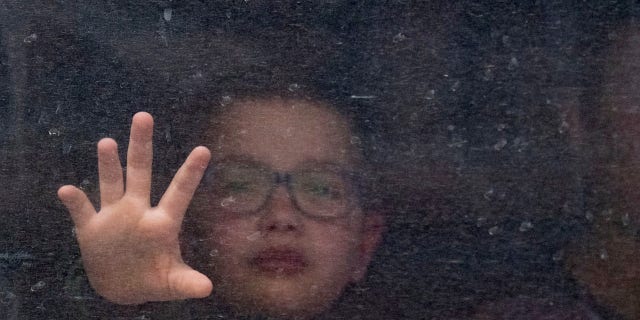 Just after a Ukrainian father said goodbye to his son in Lviv, Ukraine, with the words, "Be brave for your mother," the child is shown reaching for his father from inside the train through the water-streaked window.