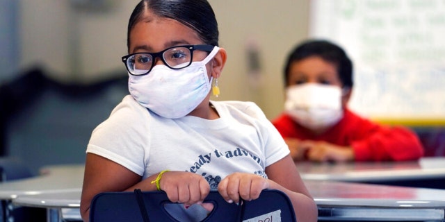 A summer school student wears a protective mask, due to concerns of the COVID-19 virus pandemic, while listening to instruction at the E.N. White School in Holyoke, Massaschusetts, on Wednesday, Aug. 4, 2021.